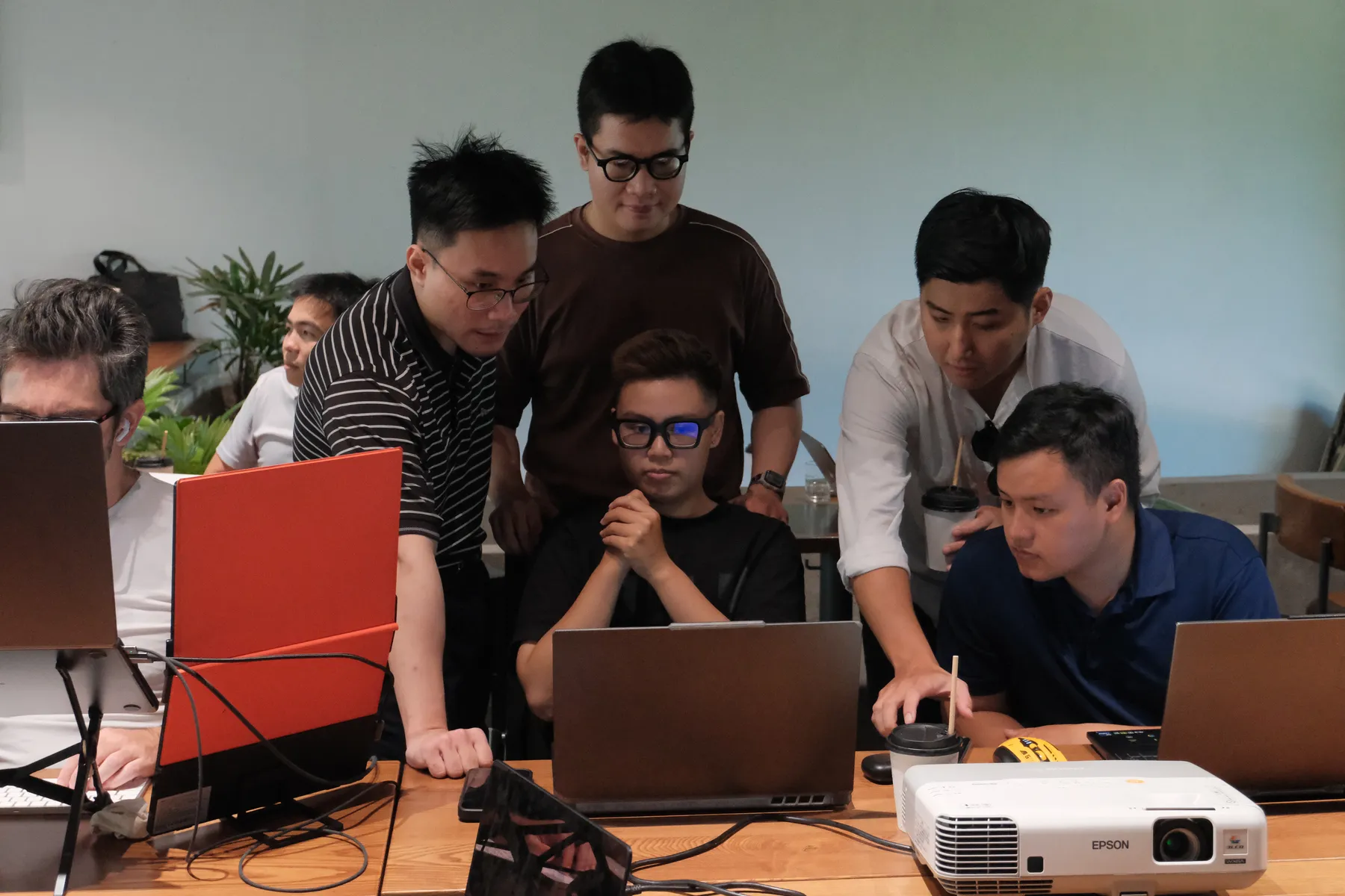 Builders huddled around a laptop together